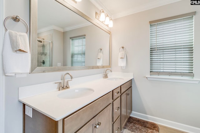 full bath featuring a stall shower, double vanity, crown molding, and baseboards