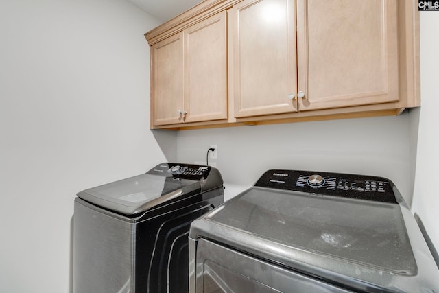 washroom featuring independent washer and dryer and cabinet space