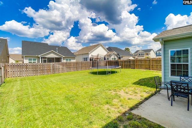 view of yard featuring a residential view, a trampoline, and a patio area