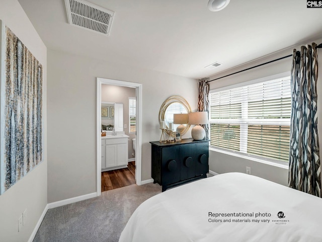 carpeted bedroom featuring multiple windows, baseboards, and connected bathroom