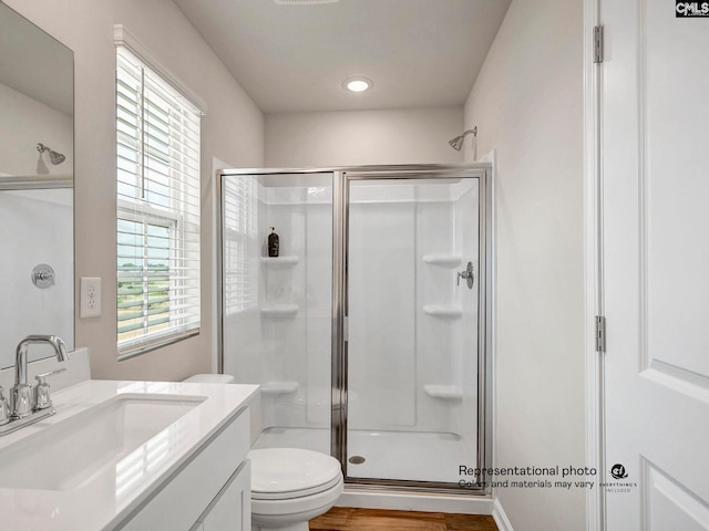 bathroom with a stall shower, vanity, toilet, and recessed lighting