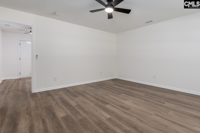 empty room featuring ceiling fan, dark wood finished floors, and baseboards