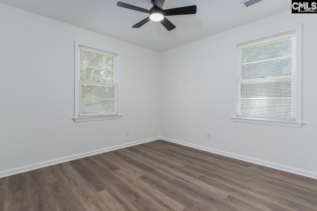 spare room featuring dark wood-type flooring, ceiling fan, and baseboards