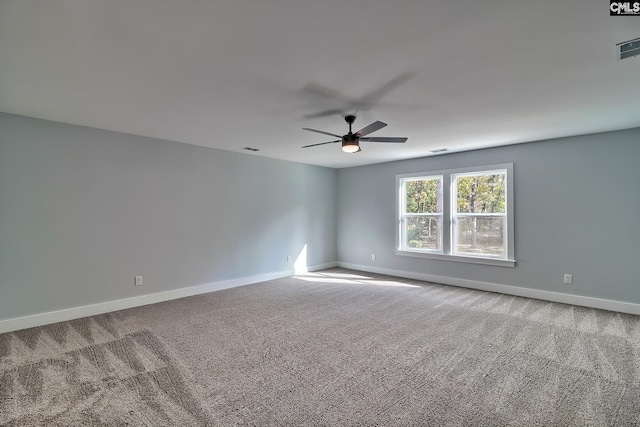 carpeted spare room featuring a ceiling fan and baseboards