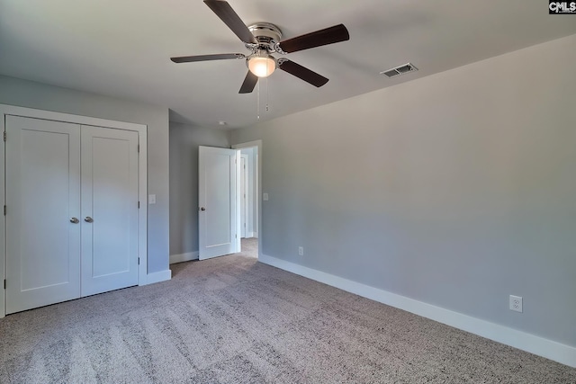 unfurnished bedroom featuring baseboards, carpet floors, a ceiling fan, and a closet