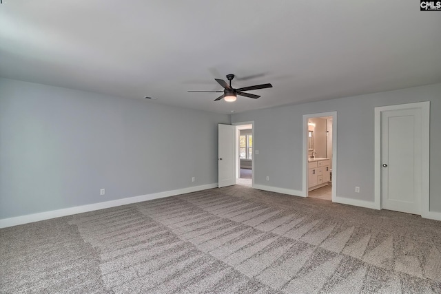 unfurnished bedroom featuring baseboards, carpet flooring, connected bathroom, and ceiling fan