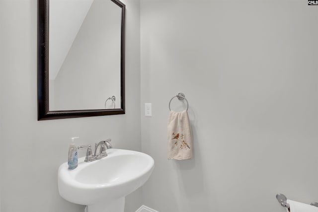 bathroom with a sink and baseboards