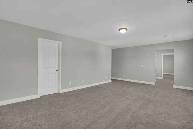 spare room featuring carpet floors and baseboards