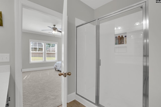 full bathroom featuring a ceiling fan, a stall shower, baseboards, and ornamental molding