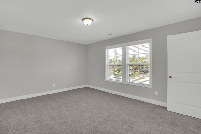 spare room featuring carpet flooring and baseboards