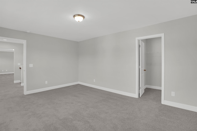 unfurnished room featuring carpet and baseboards