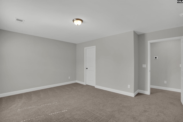 carpeted empty room featuring baseboards