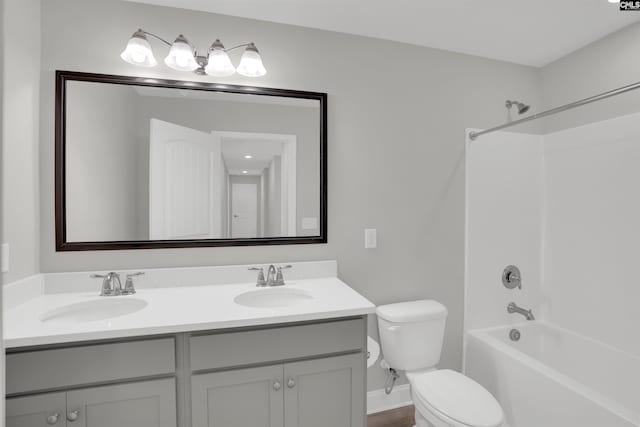 bathroom featuring toilet, double vanity, baseboards, and shower / bathtub combination