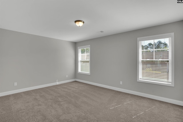 spare room with baseboards and carpet flooring