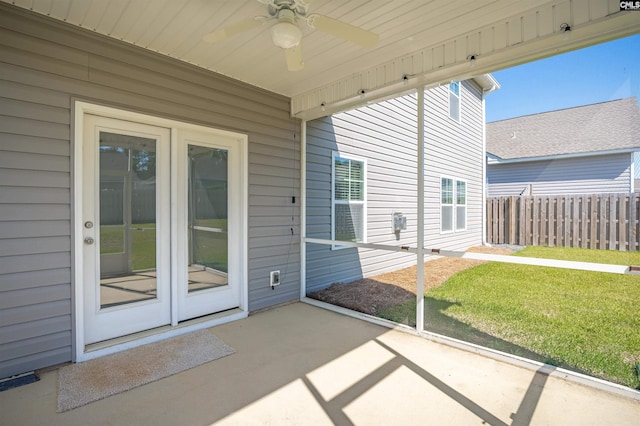 unfurnished sunroom featuring a ceiling fan