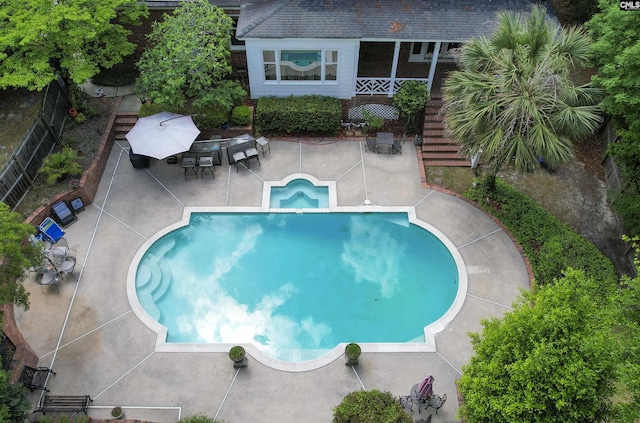 view of swimming pool with a patio, fence, and stairway
