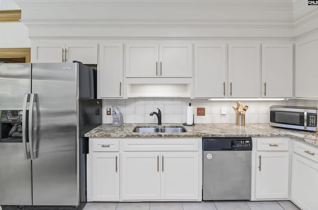 kitchen with stainless steel appliances, a sink, white cabinetry, light stone countertops, and open shelves