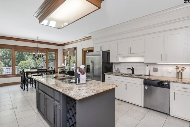 kitchen featuring stainless steel appliances, a sink, white cabinets, light tile patterned flooring, and crown molding