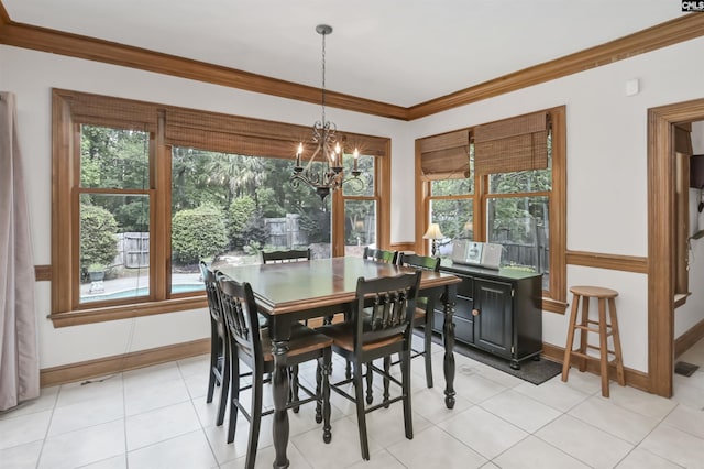 dining space with healthy amount of natural light, a chandelier, crown molding, and baseboards