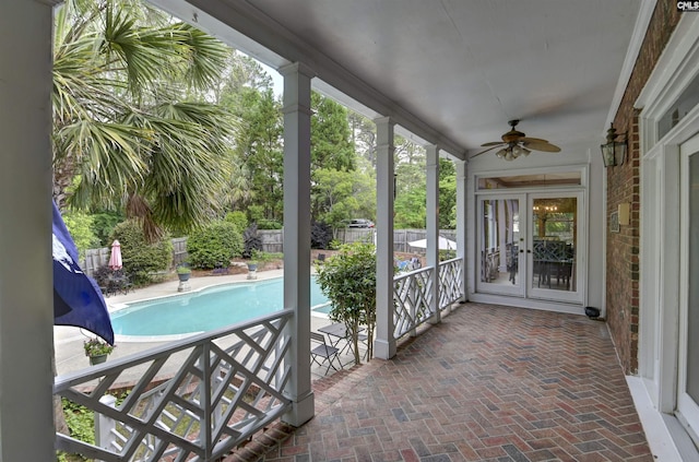 unfurnished sunroom with a ceiling fan and french doors