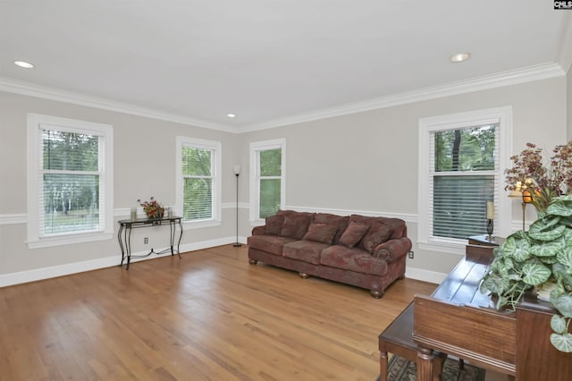 living room with light wood-style floors, crown molding, recessed lighting, and baseboards