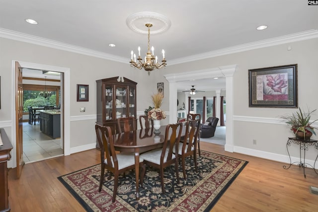 dining area with a chandelier, wood finished floors, crown molding, ceiling fan, and baseboards
