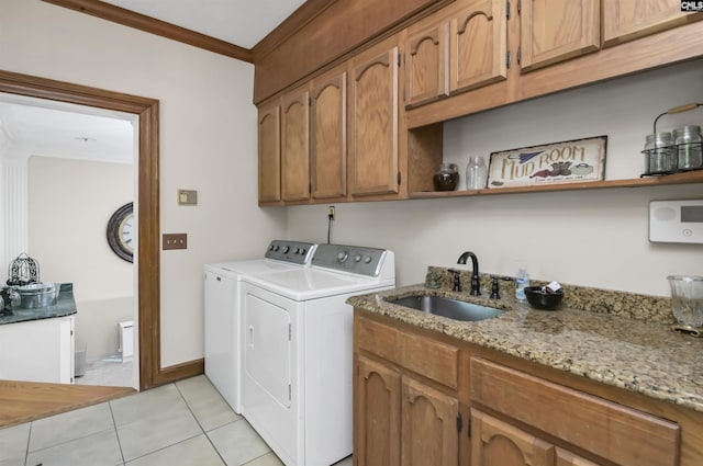 laundry room featuring washing machine and dryer, light tile patterned floors, cabinet space, and crown molding