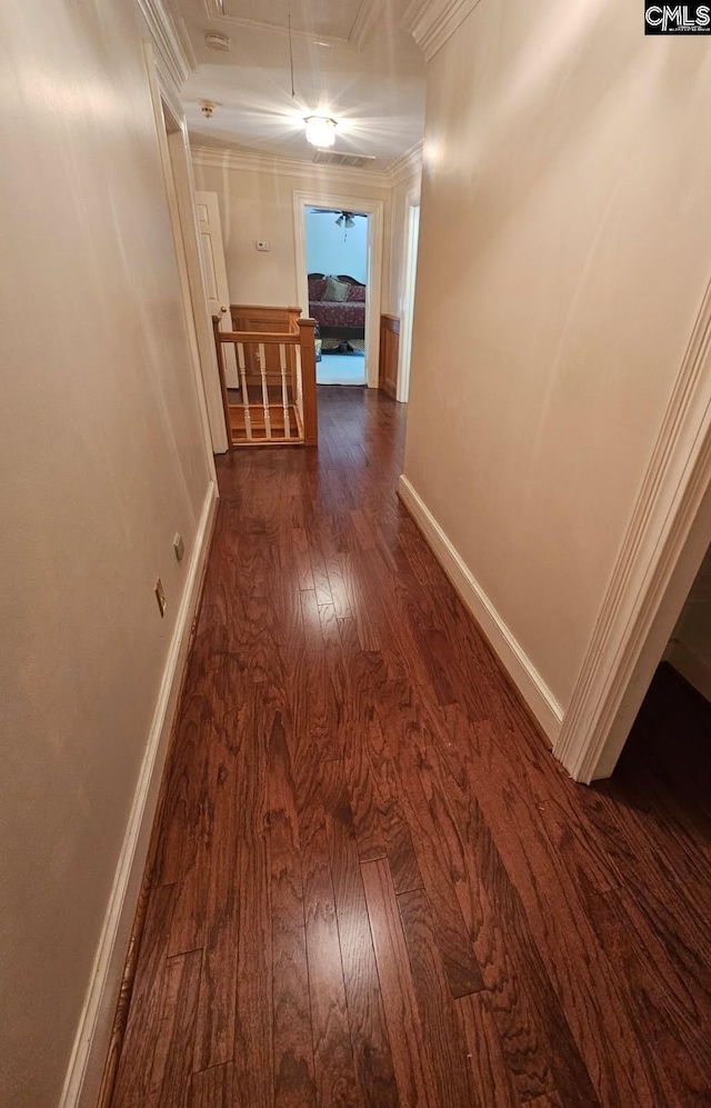 hall with attic access, an upstairs landing, dark wood-style flooring, baseboards, and ornamental molding
