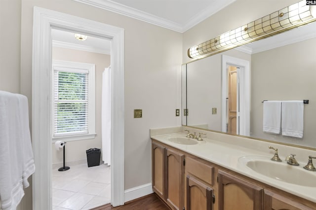 bathroom with ornamental molding, double vanity, and baseboards