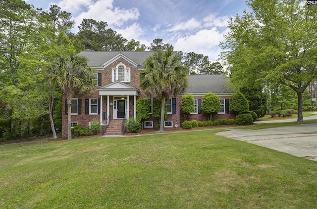 view of front of home with brick siding and a front yard