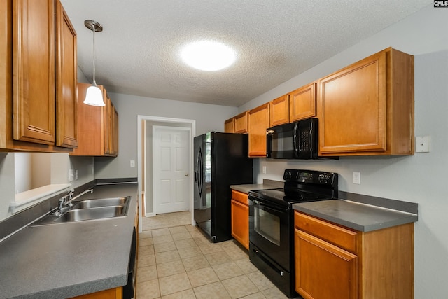 kitchen featuring black appliances, a sink, a textured ceiling, brown cabinetry, and dark countertops
