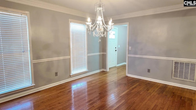 unfurnished dining area with a chandelier, hardwood / wood-style floors, baseboards, and ornamental molding