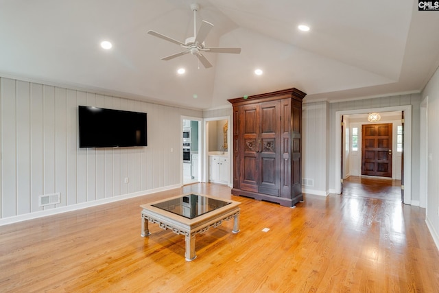 living room with vaulted ceiling, ceiling fan, baseboards, light wood-type flooring, and crown molding