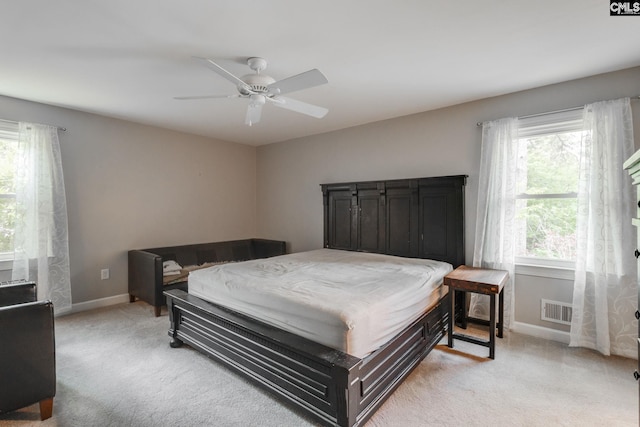 bedroom featuring light colored carpet, baseboards, and ceiling fan