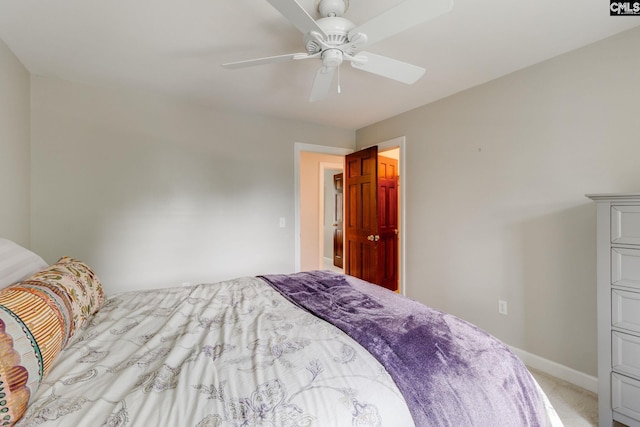 bedroom featuring light colored carpet, baseboards, and a ceiling fan