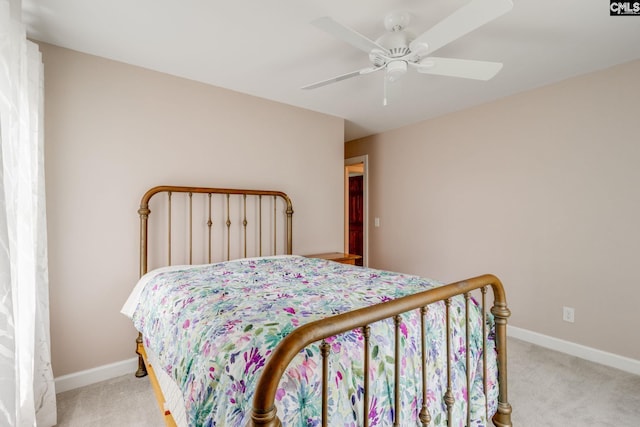 bedroom featuring light colored carpet, a ceiling fan, and baseboards