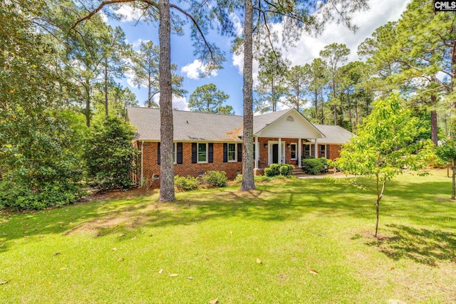 single story home featuring brick siding, covered porch, a front yard, and a shingled roof