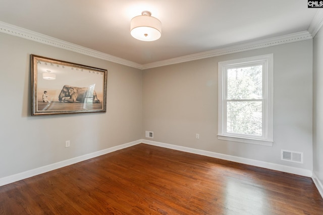 spare room featuring crown molding, dark wood-style floors, and baseboards