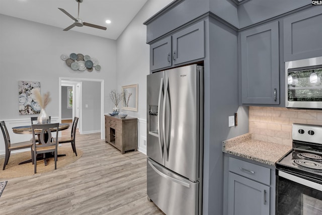 kitchen featuring appliances with stainless steel finishes, ceiling fan, tasteful backsplash, light wood-type flooring, and gray cabinetry