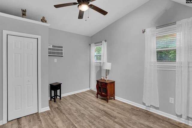 bedroom featuring lofted ceiling, wood finished floors, baseboards, a ceiling fan, and a closet