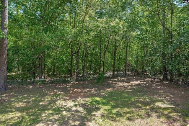 view of yard with fence and a wooded view
