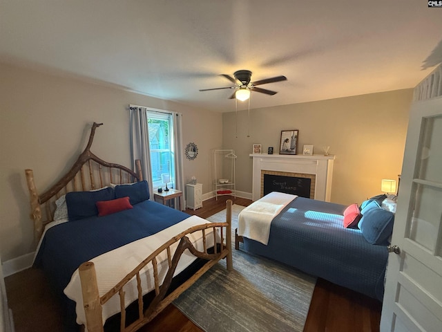 1006 W Main, Ridge Spring, SC 29129 - bedroom featuring dark wood-type flooring, baseboards, a ceiling fan, and a tiled fireplace