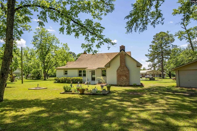1006 W Main, Ridge Spring, SC 29129 - rear view of property featuring a yard, a chimney, and a carport