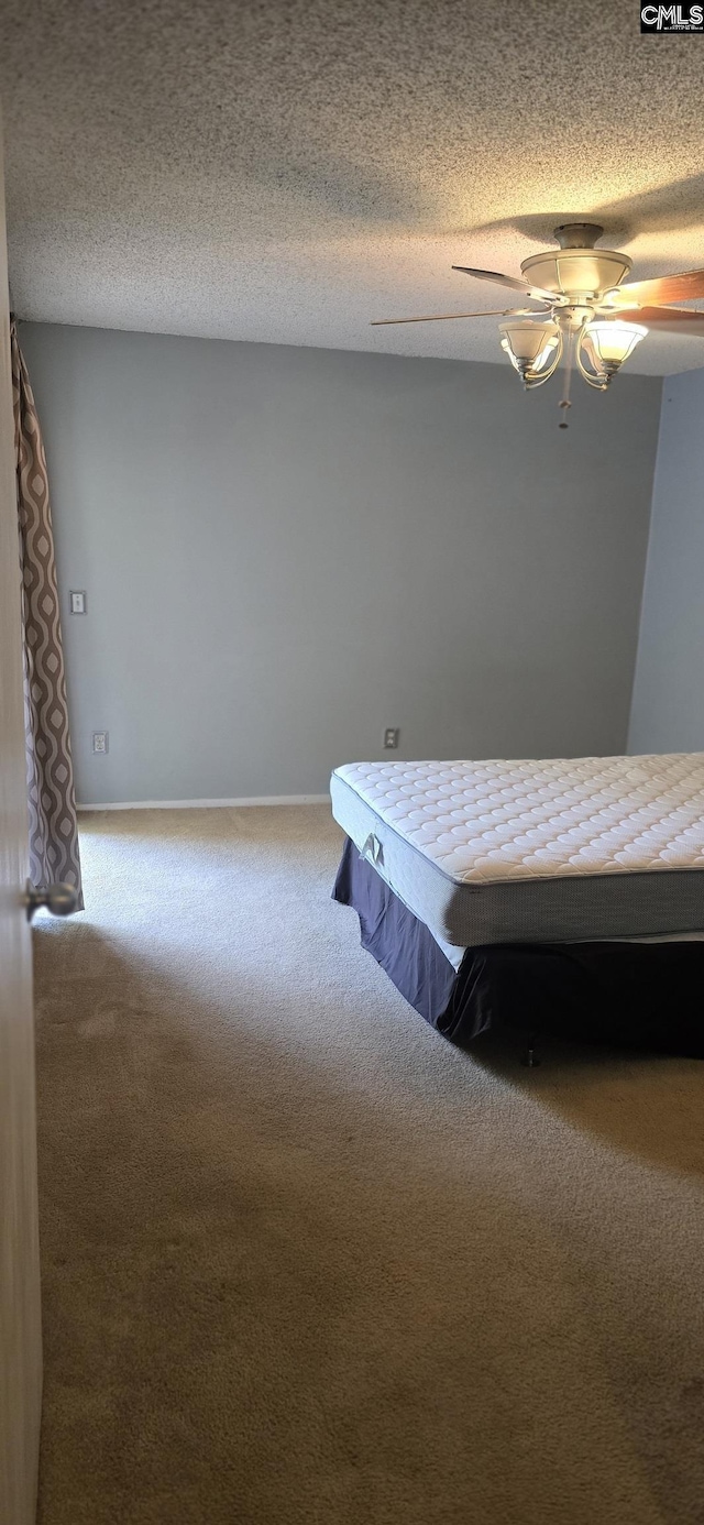 bedroom with carpet flooring, ceiling fan, a textured ceiling, and baseboards