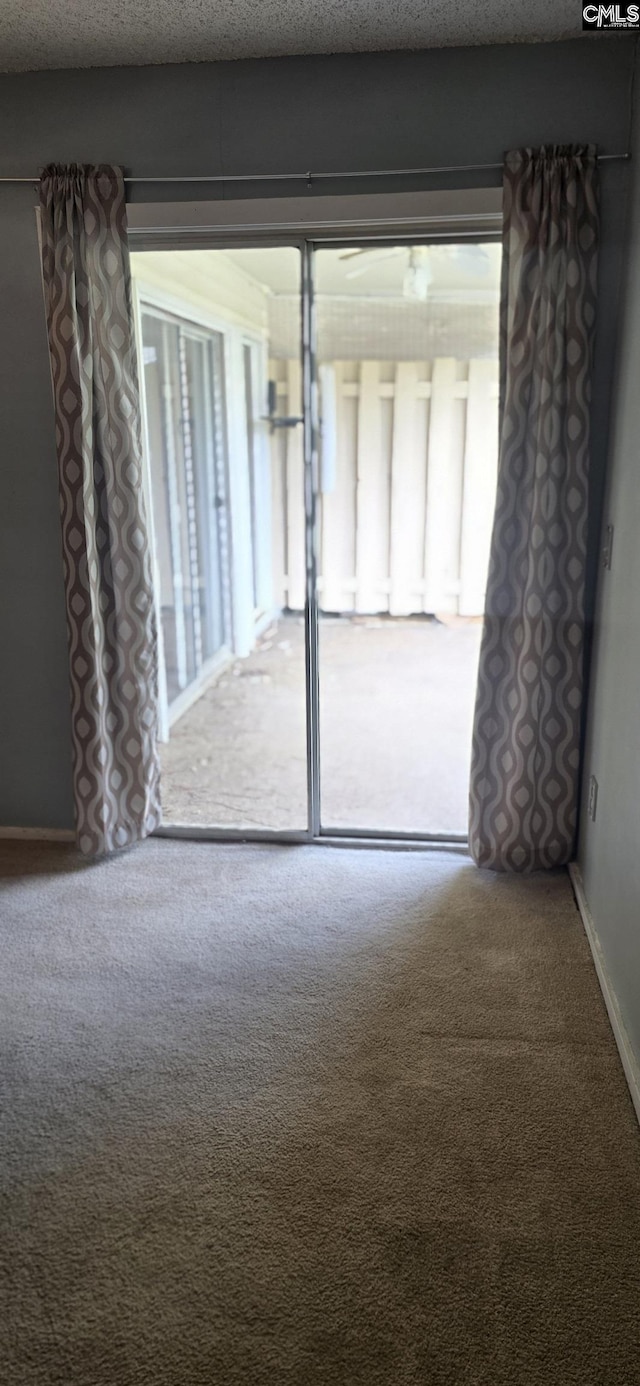 carpeted spare room with a textured ceiling