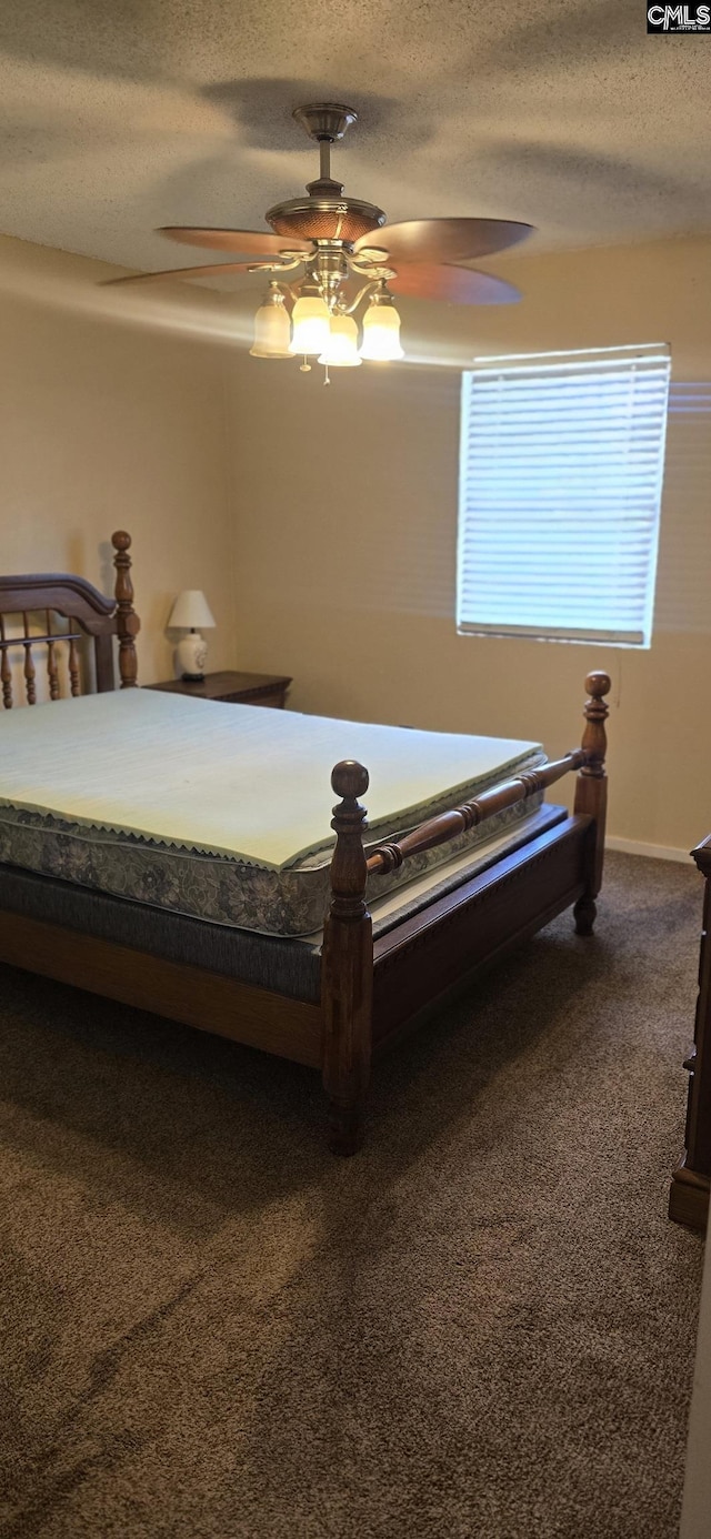 carpeted bedroom featuring a textured ceiling and a ceiling fan