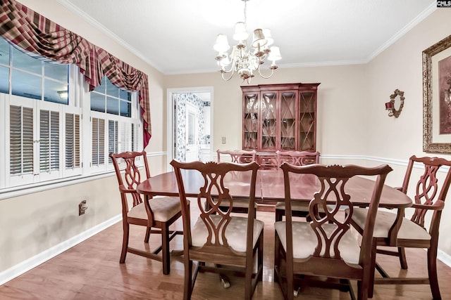 dining area with a chandelier, wood finished floors, crown molding, and baseboards