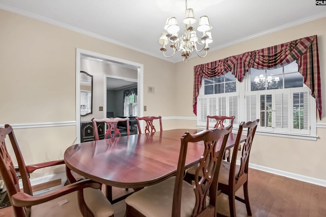 dining space with a chandelier, crown molding, hardwood / wood-style flooring, and baseboards