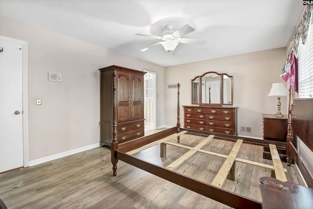 bedroom featuring light wood finished floors, baseboards, and a ceiling fan