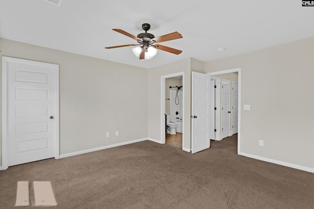 unfurnished bedroom featuring carpet, baseboards, ensuite bath, and a ceiling fan